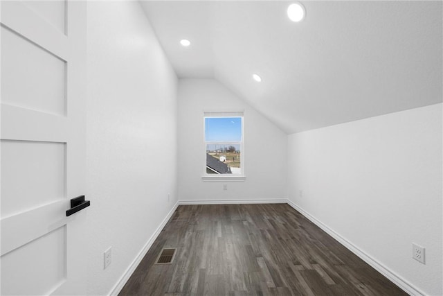 bonus room featuring baseboards, visible vents, recessed lighting, dark wood-style flooring, and vaulted ceiling