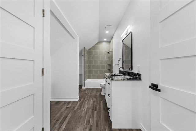 full bath featuring toilet, vaulted ceiling, shower / bathing tub combination, wood finished floors, and vanity