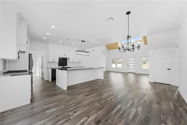 kitchen featuring visible vents, a kitchen island, white cabinets, tasteful backsplash, and a chandelier