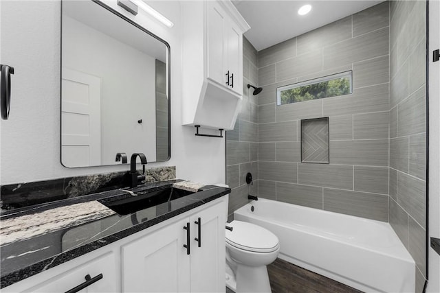 bathroom featuring shower / bathing tub combination, toilet, wood finished floors, and vanity