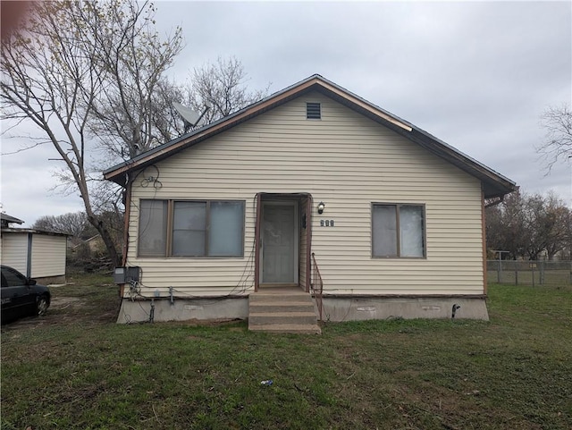 bungalow-style home with a front yard and fence