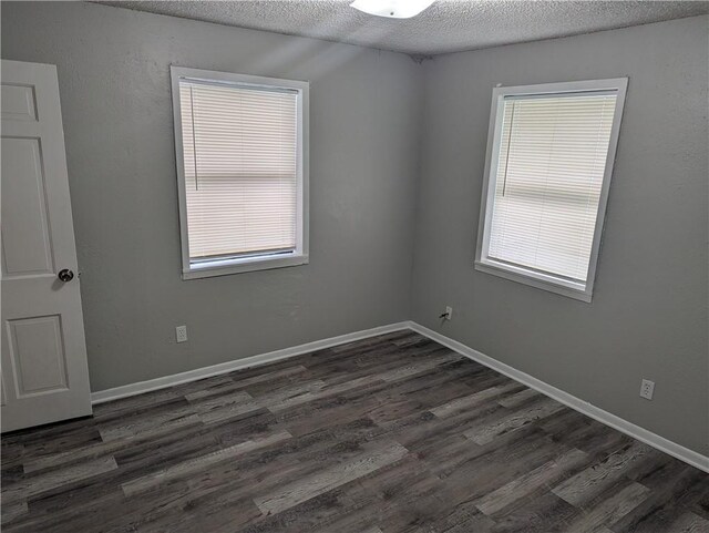 unfurnished room featuring baseboards, a textured ceiling, and wood finished floors