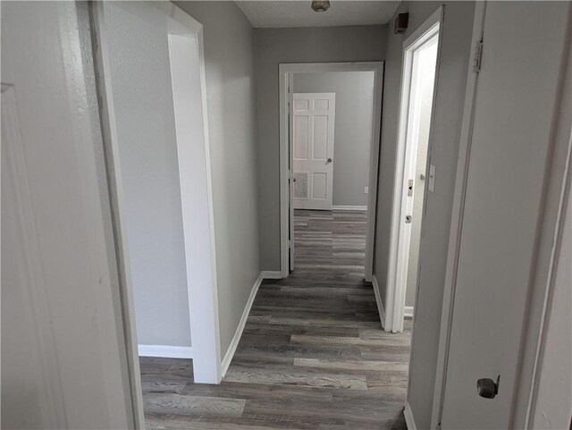 hallway with baseboards and wood finished floors