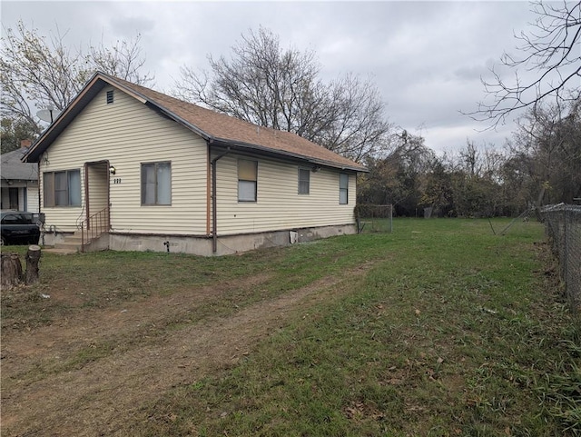 view of side of home with entry steps and a yard