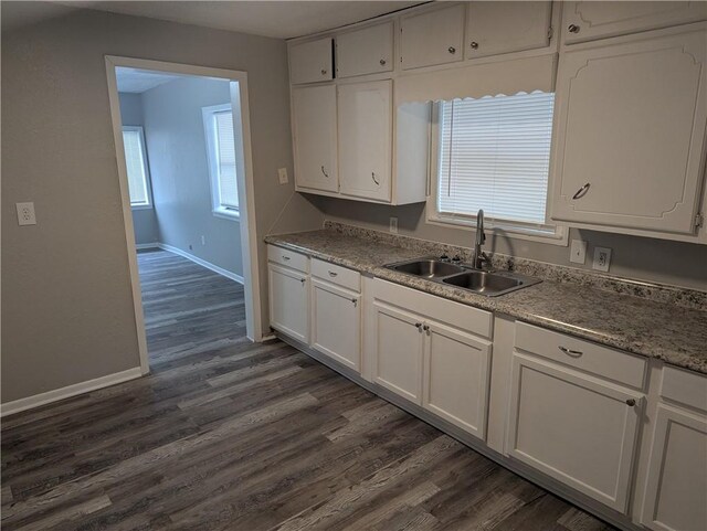kitchen featuring a sink, white cabinets, and dark wood-style flooring