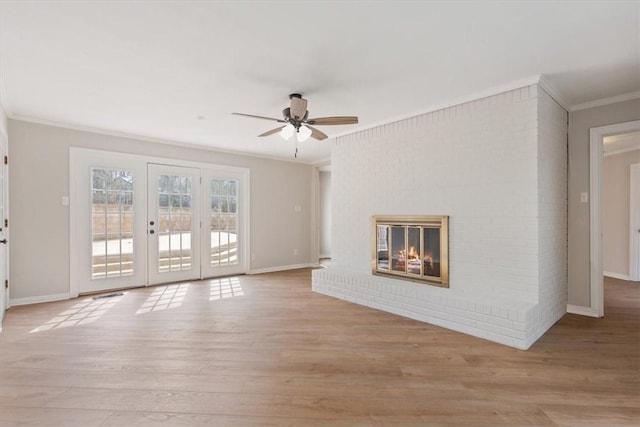 unfurnished living room featuring crown molding, light wood-style flooring, baseboards, and ceiling fan