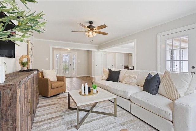 living area with a ceiling fan and ornamental molding
