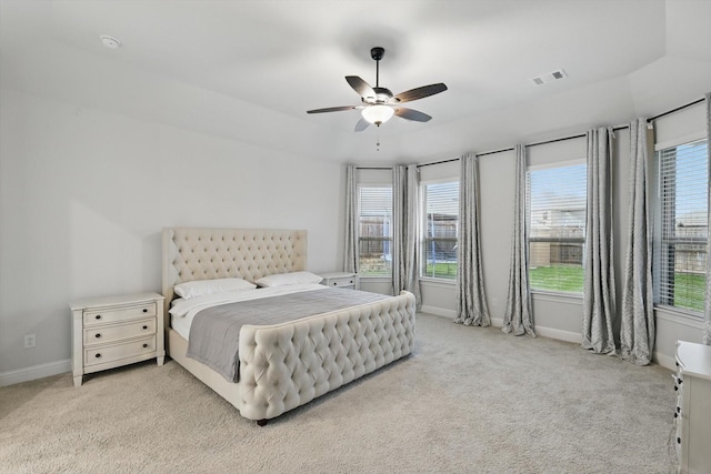 carpeted bedroom with visible vents, a ceiling fan, and baseboards