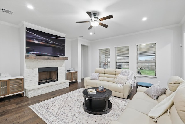 living area with ornamental molding, a ceiling fan, wood finished floors, and visible vents