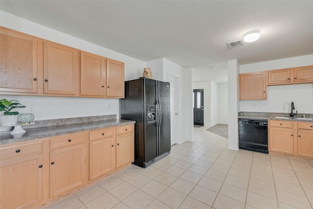 kitchen with visible vents, light brown cabinetry, light tile patterned flooring, black appliances, and a sink