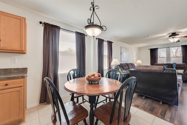 dining area featuring plenty of natural light, a ceiling fan, baseboards, and light tile patterned flooring