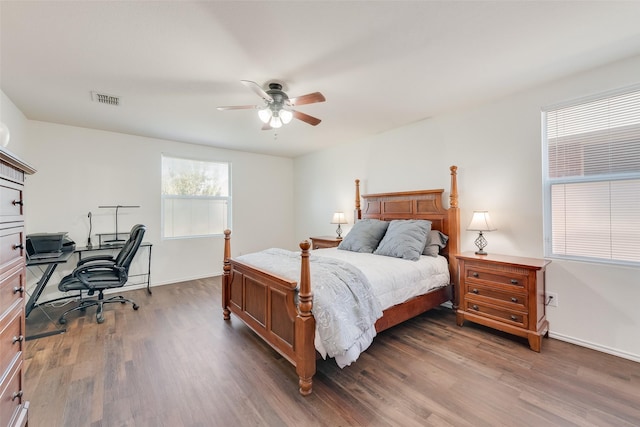 bedroom featuring ceiling fan, wood finished floors, visible vents, and baseboards