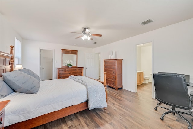 bedroom featuring visible vents, connected bathroom, light wood-type flooring, and baseboards