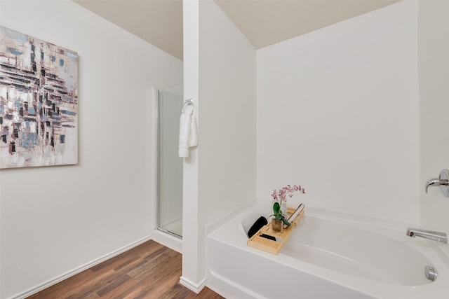 full bathroom featuring a stall shower, baseboards, a garden tub, and wood finished floors