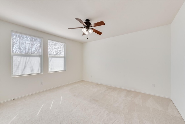 unfurnished room with baseboards, light carpet, and a ceiling fan
