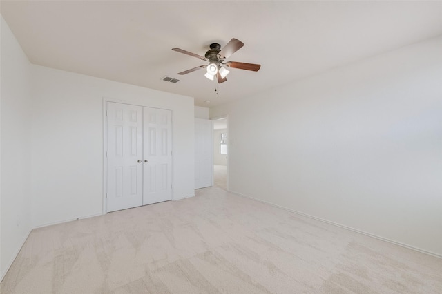 unfurnished bedroom with visible vents, ceiling fan, baseboards, light carpet, and a closet