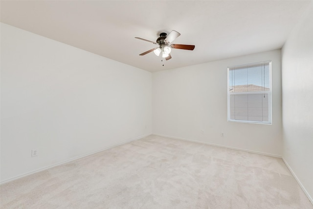 unfurnished room with a ceiling fan, light colored carpet, and baseboards