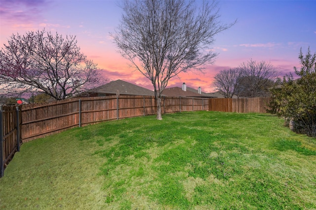 yard at dusk with a fenced backyard