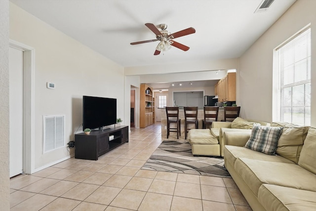 living room with ceiling fan, visible vents, and light tile patterned floors