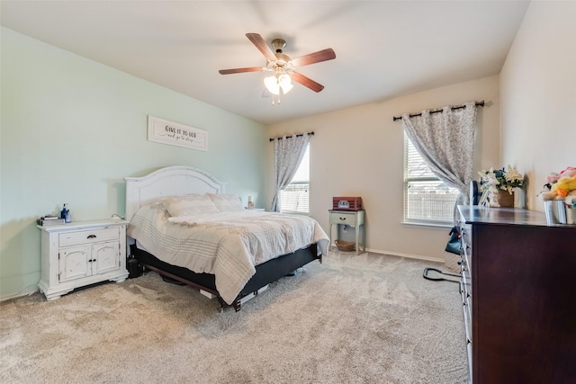 bedroom featuring light colored carpet, a ceiling fan, and baseboards