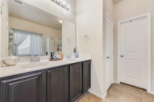 full bathroom with tile patterned floors, double vanity, a sink, visible vents, and a stall shower
