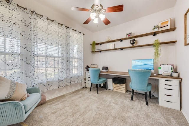 office area featuring baseboards, a ceiling fan, carpet floors, and built in desk