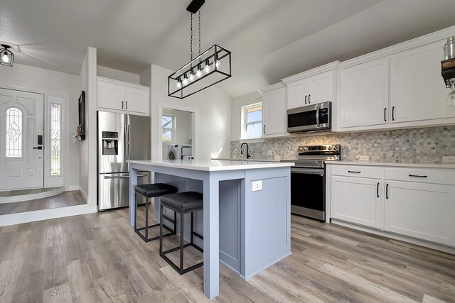 6837 Briar Rd, Azle, TX 76020 - kitchen with stainless steel appliances, a center island, washer and dryer, decorative backsplash, and light countertops