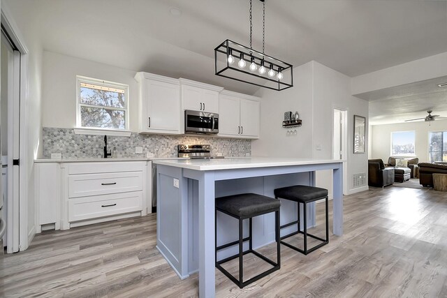 6837 Briar Rd, Azle, TX 76020 - kitchen with stainless steel appliances, open floor plan, tasteful backsplash, light wood finished floors, and a kitchen bar
