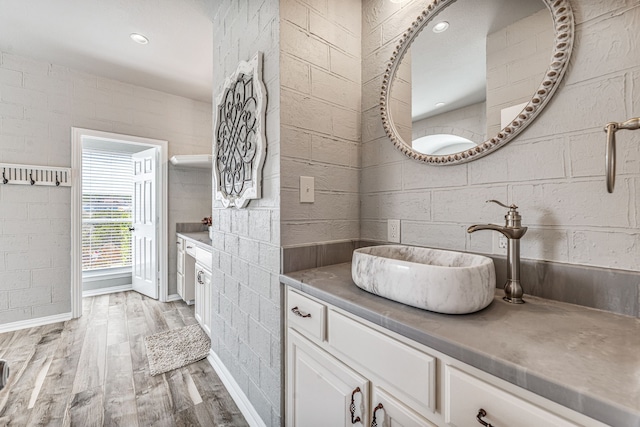 bathroom with wood finished floors, vanity, baseboards, and recessed lighting
