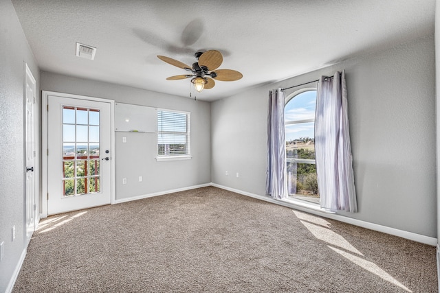 spare room with ceiling fan, baseboards, visible vents, and carpet floors