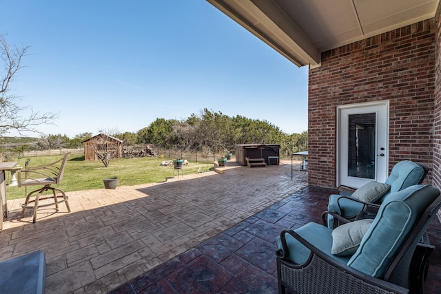 view of patio / terrace with a fenced backyard, an outdoor structure, a hot tub, and a storage unit