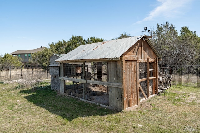 view of poultry coop featuring fence and a lawn