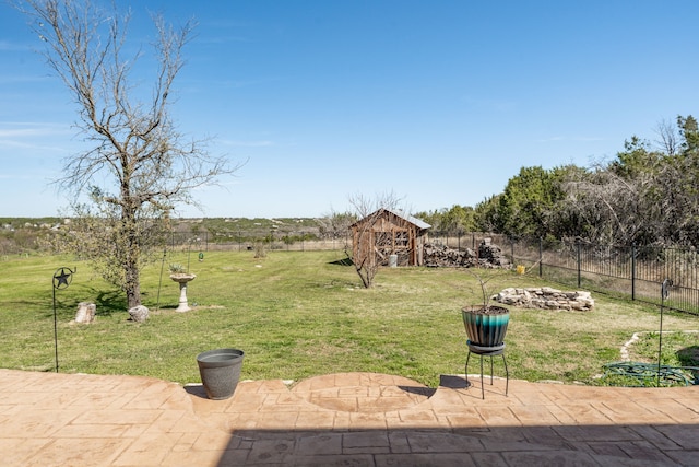 view of yard featuring a storage shed, a fenced backyard, an outdoor structure, and a patio