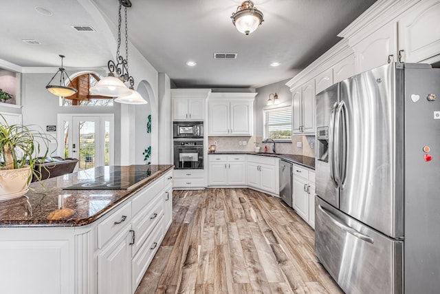 kitchen featuring visible vents, white cabinetry, black appliances, and light wood-style flooring