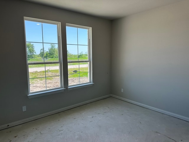 spare room with unfinished concrete floors and baseboards