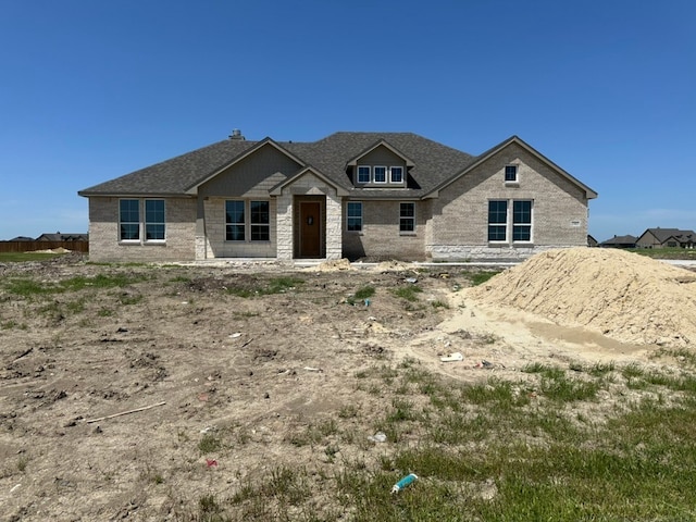 view of front of home with stone siding and a shingled roof