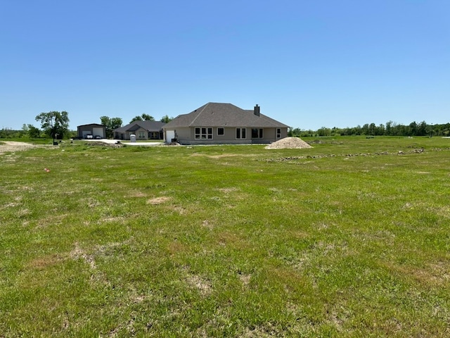view of yard featuring a garage and a rural view