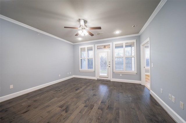 spare room with dark wood-style floors, a ceiling fan, visible vents, baseboards, and crown molding
