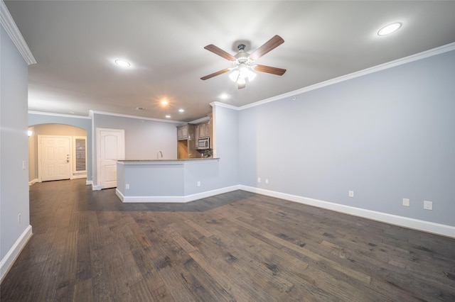 unfurnished living room featuring dark wood-style floors, a ceiling fan, baseboards, recessed lighting, and arched walkways