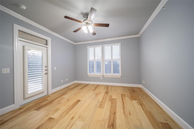 empty room featuring crown molding, wood finished floors, baseboards, and ceiling fan