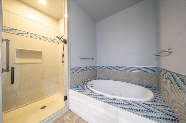 full bathroom featuring tile patterned floors, a stall shower, and a whirlpool tub