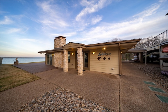 view of front of home featuring a chimney and a water view