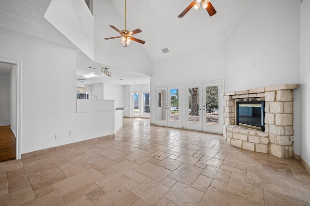 5327 Dusty Rd, Athens, TX 75752 - unfurnished living room featuring ceiling fan, high vaulted ceiling, stone tile floors, a fireplace, and baseboards