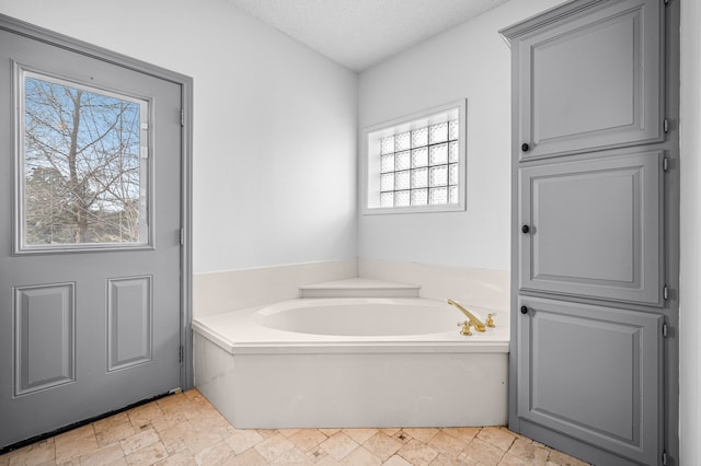 5327 Dusty Rd, Athens, TX 75752 - bathroom with a garden tub, stone finish flooring, and a textured ceiling