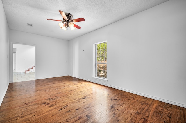 5327 Dusty Rd, Athens, TX 75752 - empty room featuring a ceiling fan, wood finished floors, stairs, a textured ceiling, and baseboards