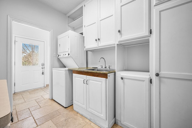 5327 Dusty Rd, Athens, TX 75752 - laundry room featuring estacked washer and dryer, stone tile floors, and cabinet space