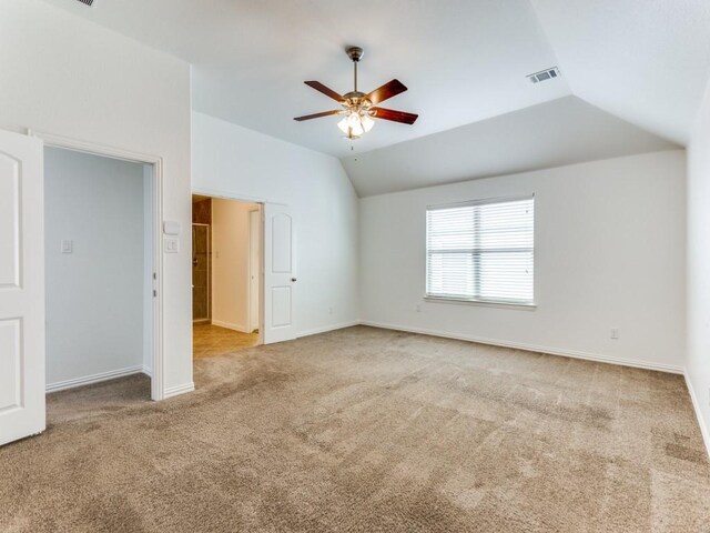 unfurnished bedroom with a ceiling fan, carpet, baseboards, lofted ceiling, and visible vents