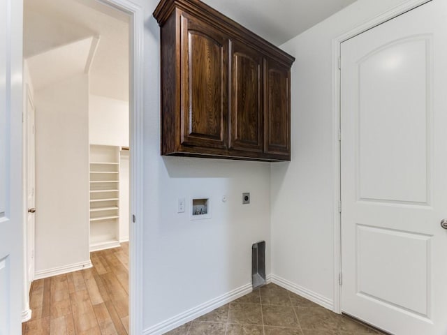 laundry area with hookup for an electric dryer, hookup for a gas dryer, baseboards, cabinet space, and washer hookup
