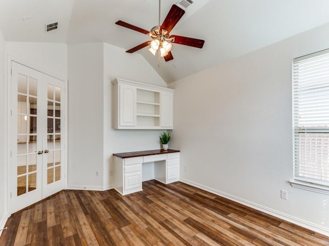 unfurnished office with french doors, vaulted ceiling, built in desk, a ceiling fan, and wood finished floors