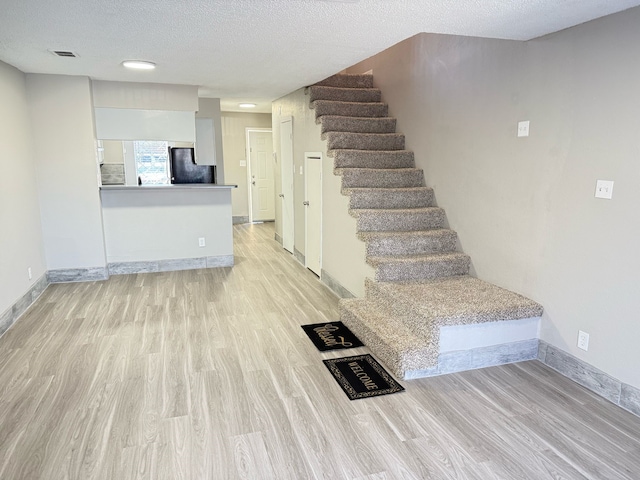 2240 Aspen Dr, Dallas, TX 75227 - stairway with visible vents, baseboards, a textured ceiling, and wood finished floors
